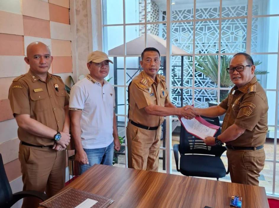 Pj Bupati Konawe Harmin Ramba saat memberikan SK penunjukan Plt Kadia Dikdukcapil kepada Asisten II Muh. Akbar. Foto: Ist.