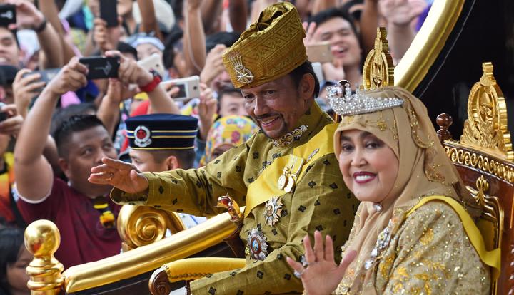 Sultan Brunei Darussalam, Hassanal Bolkiah dan Ratu Saleha, dukuk menyapa warga. Foto: Repro AFP