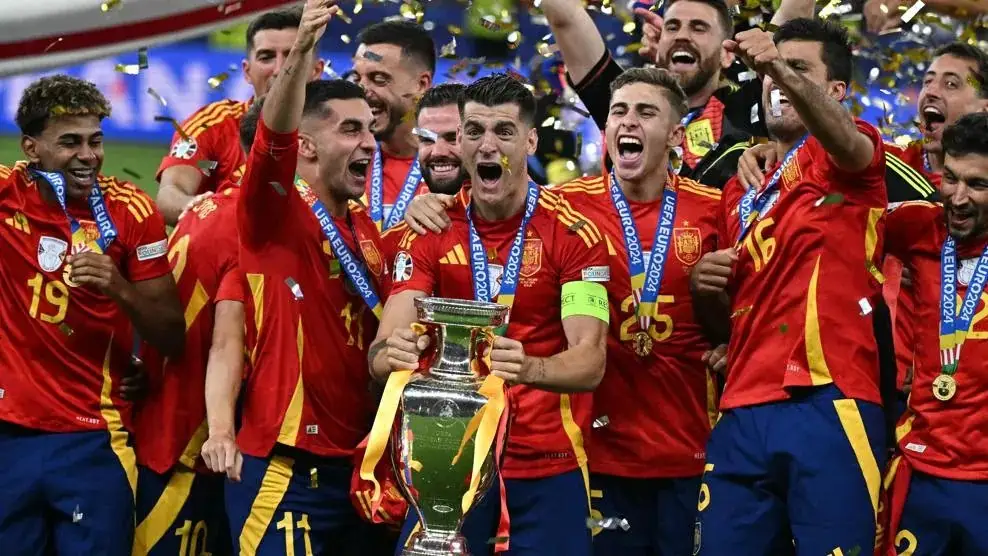 Para pemain Spanyol bersama trofi mereka merayakan gelar juara Euro 2024 usai mengalahkan Inggris 2-1 di final di Olympiastadion, Berlin, Senin (15/7/2024) dinihari WIB. Foto: Repro euro.com