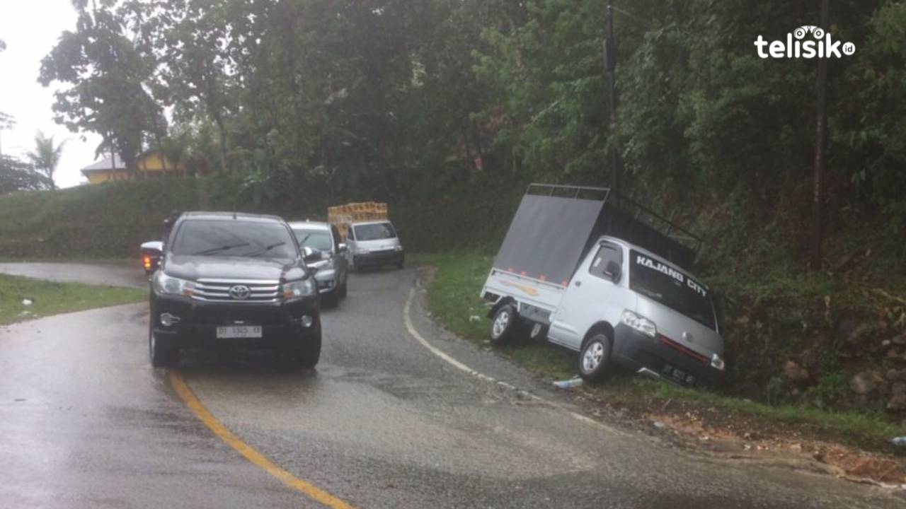 Tampak mobil Daihatsu Grand Max terperosok ke dalam got. Foto: Bambang Sutrisno/Telisik