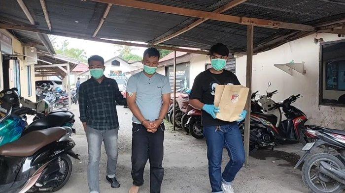 Pelaku saat dijemput pihak berwajib, dengan kondisi tangan terborgol. Foto: Repro tribunnews.com
