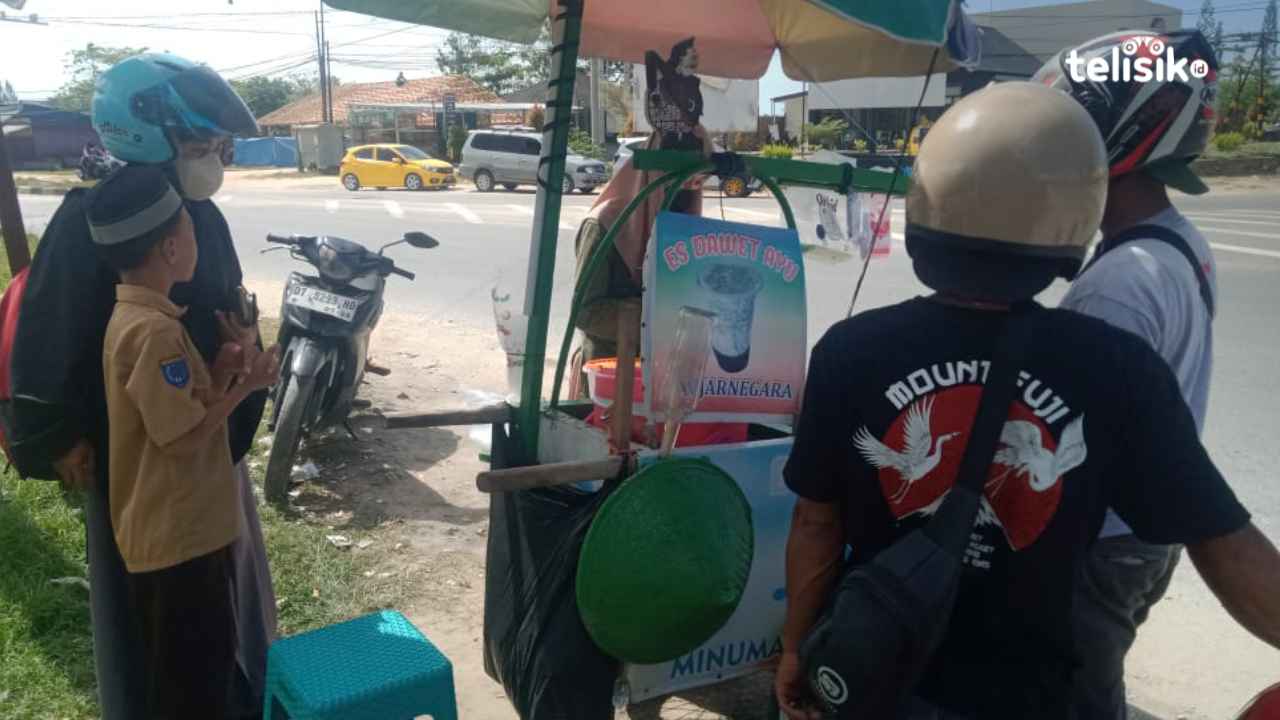 Rifka sedang melayani pembeli es dawet dagangannya. Foto: Wa Ode Hesti/Telisik
