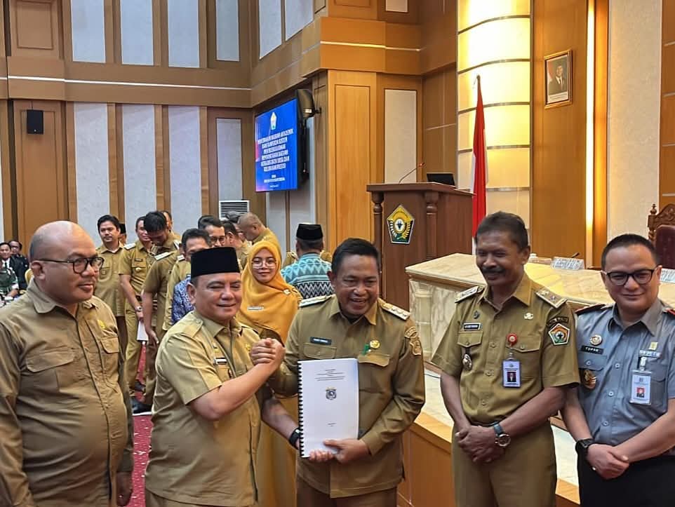 Pj Bupati Muna Barat, Pahri Yamsul saat menerima naskah akademik dan draf rancangan peraturan Daerah berbasis data presisi. Foto: Ist