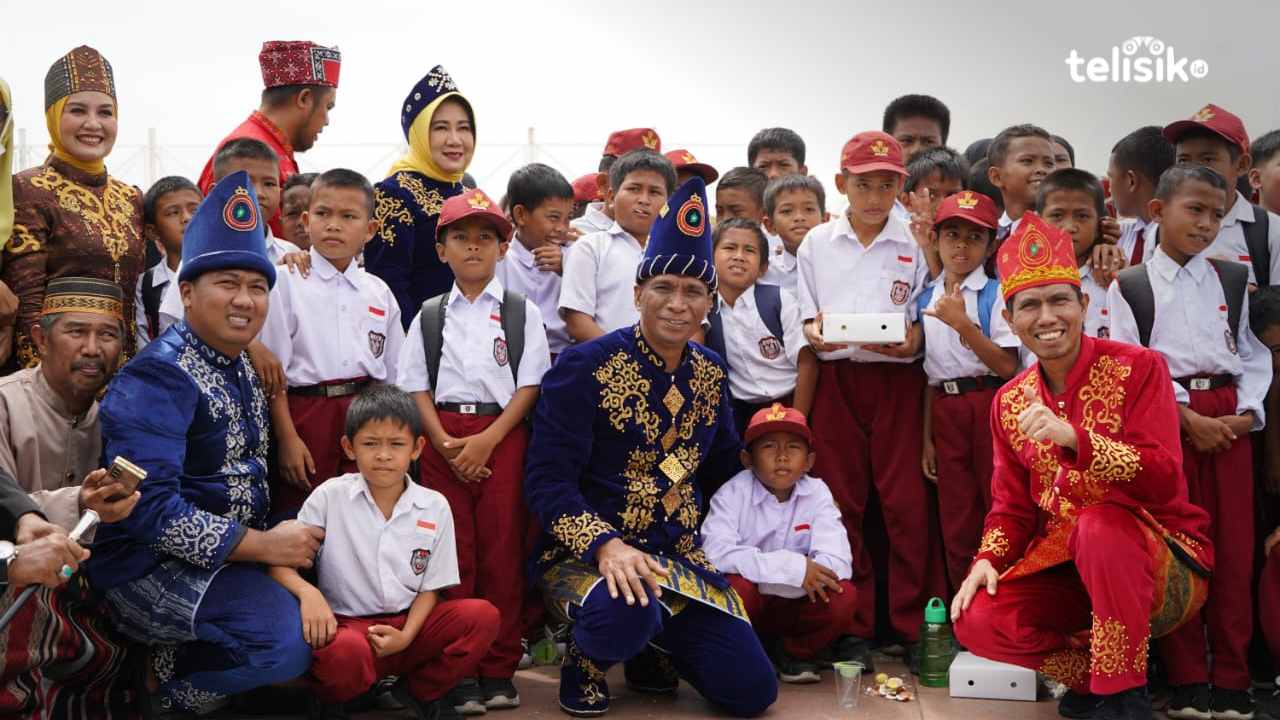 Fotret Pj Bupati Kolaka Utara, Yusmin (tengah) bersama Ketua DPRD Kolaka Utara, Fitra Yudi (kiri) dan Wakil Ketua Komisi II DPR RI, Bahtra Banong  (kanan) bersama murid SD usai makan bergizi gratis di alun-alun. Foto: Muh. Risal H/Telisik