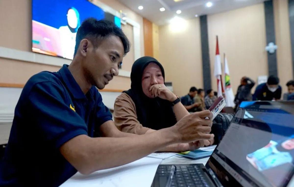 Salah satu pegawai membantu warga yang mendaftarkan diri pada Program Kartu Prakerja. Foto: Repro Antara