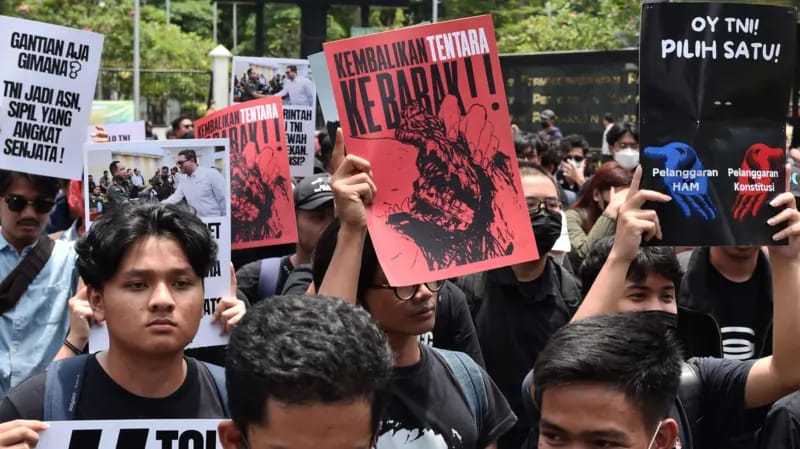 Pengunjuk rasa memegang poster saat aksi di depan pintu gerbang Pancasila, Gedung DPR, Jakarta. Foto: Repro Antara.