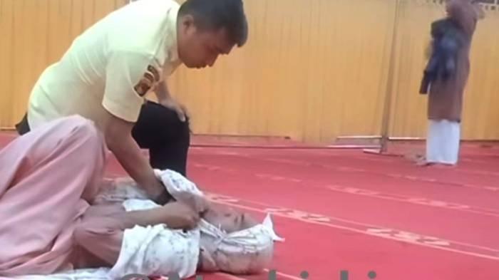 Pria bermukenah di saf wanita ditampar dan dibanting satpam masjid. Foto: Repro Tribunnews.
