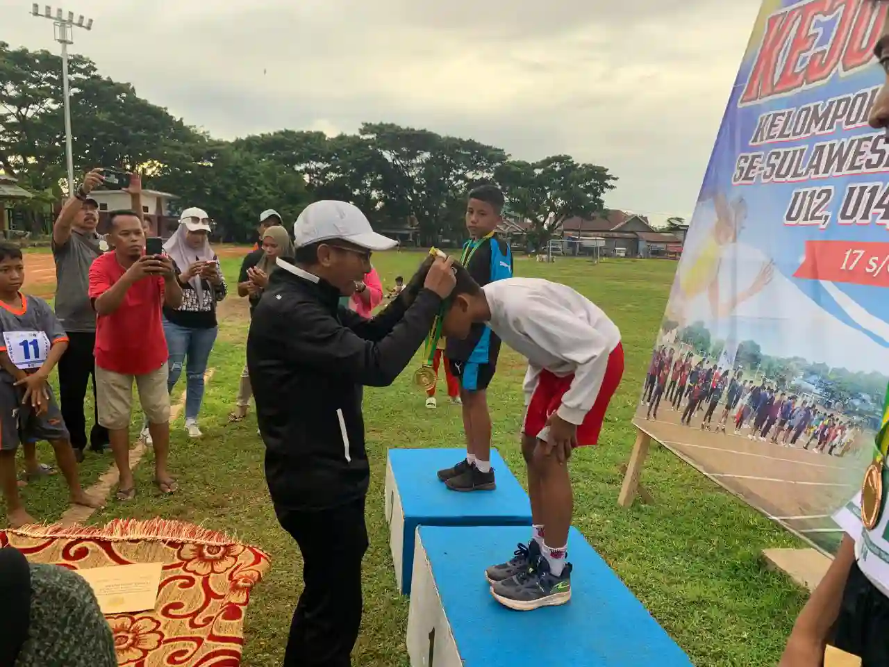 Pengalungan medali emas kepada salah satu atlet dalam Kejurda Sultra 2025 oleh Pj Sekda Buton Selatan, La Ode Darussalam. Foto: Diskominfo Buton Selatan.