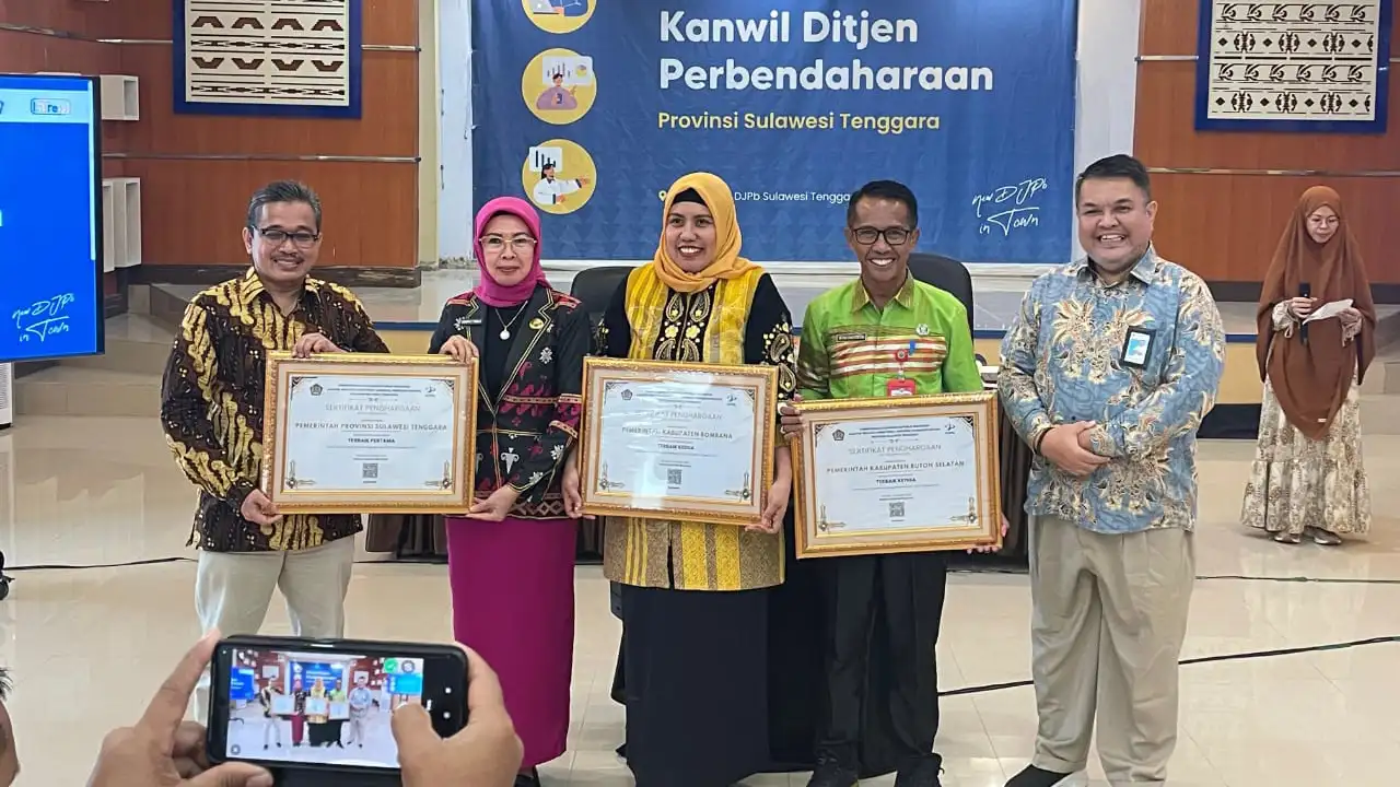 Pj Sekda Buton Selatan, La Ode Darussalam (baju hijau) saat menerima penghargaan pengelolaan DAK Fisik dari Kepala Kantor Wilayah DJPb Sulawesi Tenggara. Foto: DisKominfo Buton Selatan.