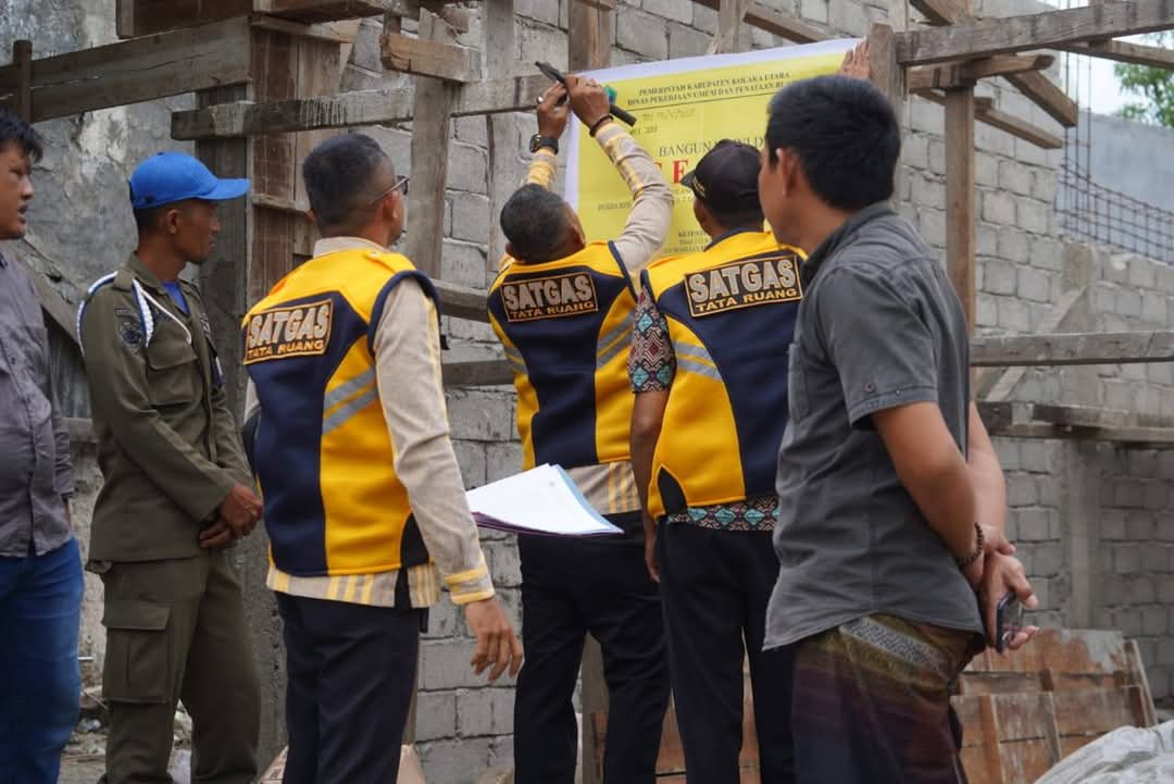 Proses penyegelan salah satu ruko di Desa Patowonu oleh Satgas Tata Ruang PUPR Kolaka Utara disaksikan pemilik bangunan. Foto: Diskominfo Kolaka Utara