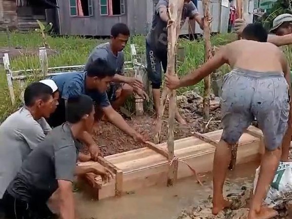 Para warga saat mengubur jenazah di dalam air menggunakan peti atau Tabala. Foto: Repro detik.com