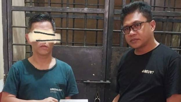 Terduga palaku tindak pidana penggelapan, inisial IA (kiri) diamanakan oleh personel Polsek Mandonga di sel tahanan. Foto: Ist.