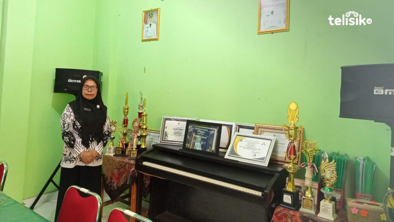 Kepala SDN 1 Kendari, Suriati, menunjukkan deretan piala dan piagam yang diraih para siswa, Jumat (25/7/2025). Foto: Abdul Jabaru Hidi/Telisik