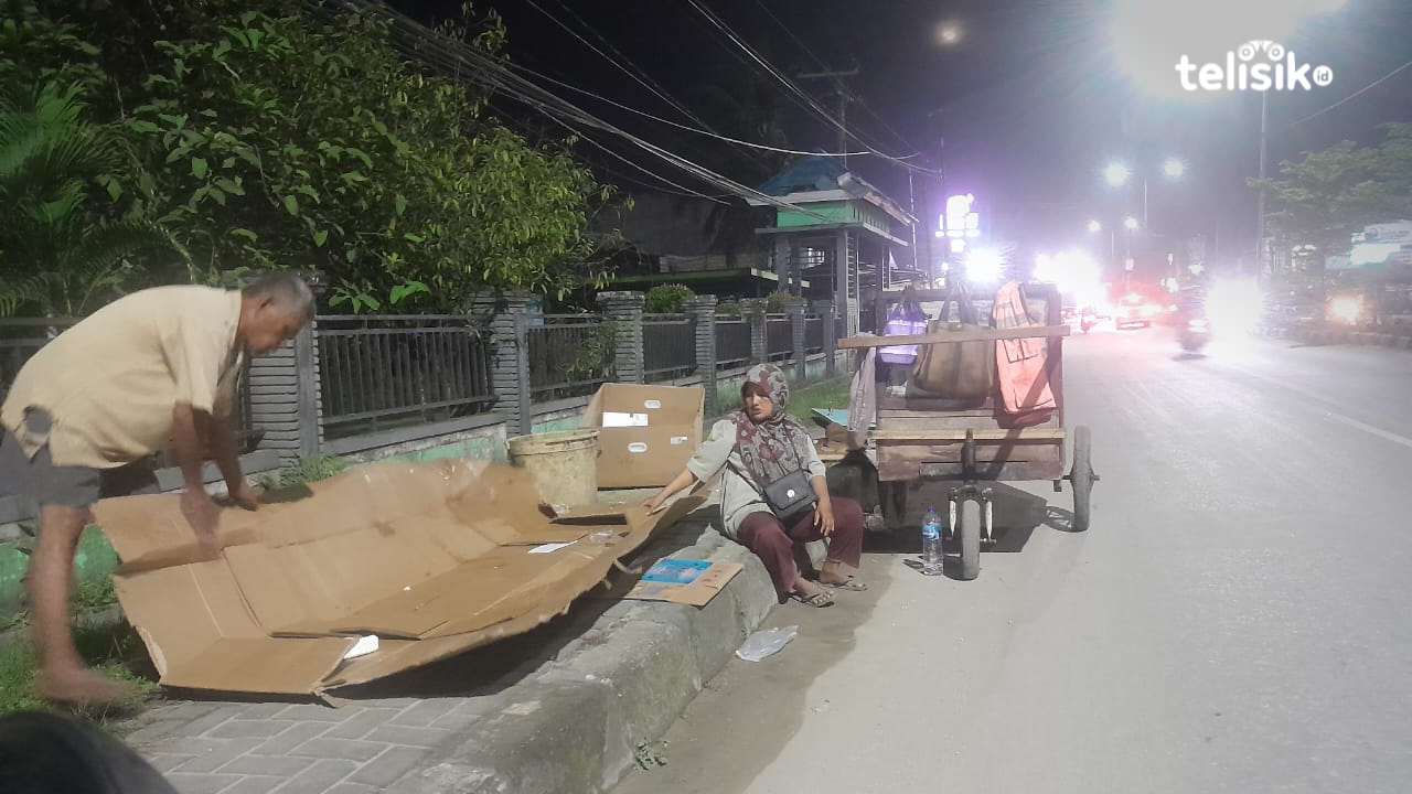Arifuddin bersama istri saat merapikan kardus yang didapatkannya di sekitar Jalan AH Nasution, Kelurahan Kambu, Kecamatan Kambu, Kota Kendari, Jumat (18/7/2025) malam. Foto: R. Anugrah/Telisik