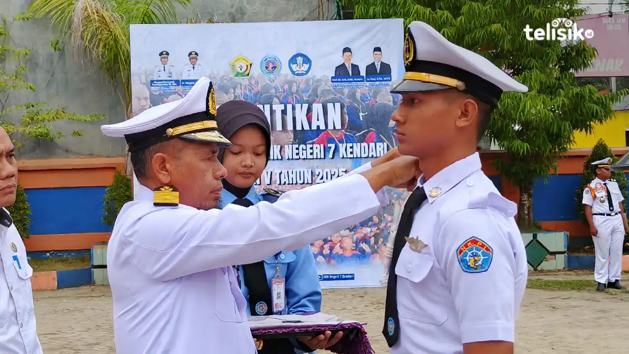 Seorang taruna terbaik SMKN 7 Kendari menerima penyematan atribut secara simbolis pada prosesi pelantikan. Penyematan ini menjadi tanda resmi pengukuhan siswa sebagai taruna-taruni. Foto: Gusti Kahar/Telisik.