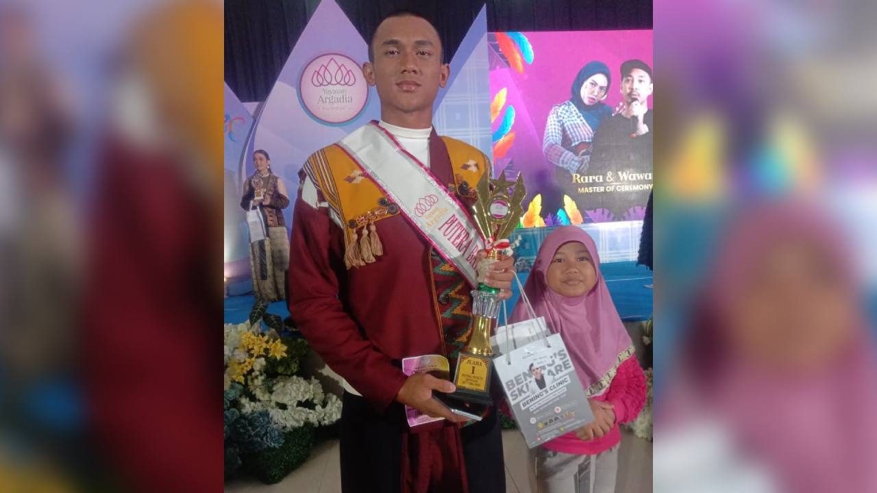 Dimaz Miftah Faiz Pratama (kiri), siswa SMKN 7 Kendari berfoto bersama adiknya dengan memegang piala juara 1 lomba fashion show Putra Putri Indonesia. Foto: Ist.
