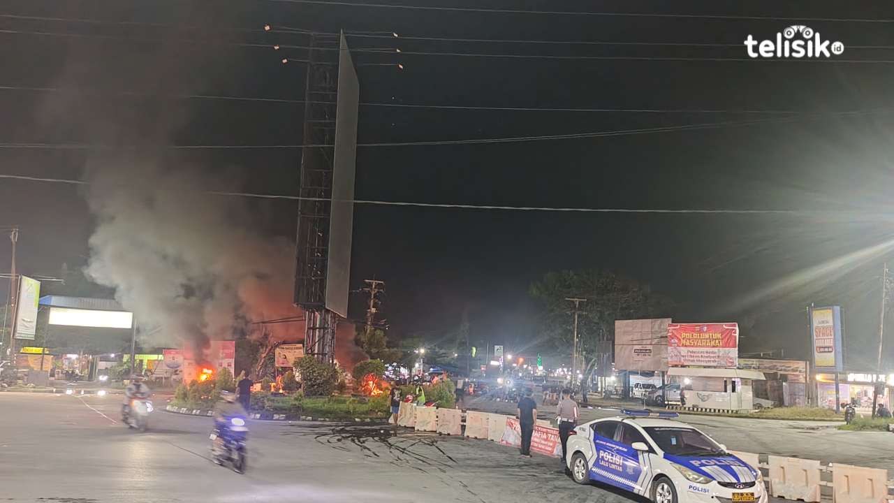 Sejumlah warga dan pengendara berkumpul di bundaran Tapak Kuda, Kelurahan Korumba, saat aksi blokade jalan berlangsung, Rabu (29/10/2025) malam. Warga tampak berjaga di sekitar lokasi sambil memantau situasi. Foto: Gusti Kahar/Telisik