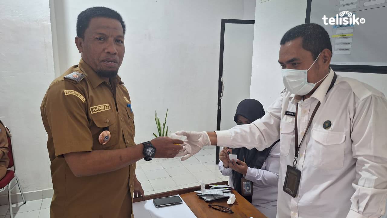 Kepala BKPSDM Muna, Hidayat Ardi Ponto (kiri), menyerahkan urinenya ke petugas BNNK untuk diperiksa, Senin (13/10/2025). Foto: Sunaryo/Telisik
