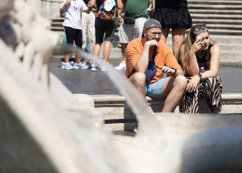 Wisatawan beristirahat di tengah gelombang panas di Piazza di Spagna di Roma, Italia. Foto: Li Jing/Xinhua