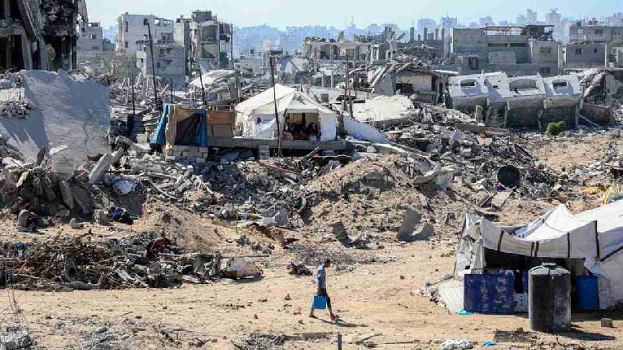 Seorang warga Palestina terlihat di sebuah jalan yang dipenuhi bangunan yang hancur di kamp pengungsi Jabalia, Jalur Gaza utara, pada 27 Oktober 2025. Foto: Rizek Abdeljawad/Xinhua