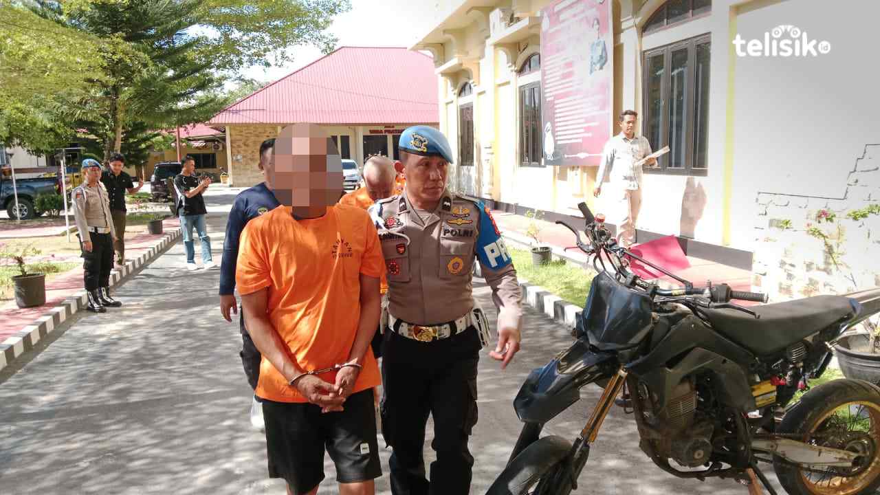Pria Inisial DS (47) tersangka tidak pidana pencabulan anak saat digelandang personel kepolisian Polresta Kendari, Jumat (14/11/2025). Foto: Hamlin/Telisik