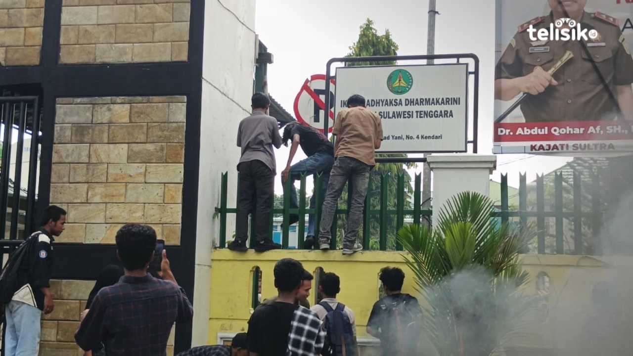 Beberapa mahasiswa berusaha memanjat pagar kantor Kejati Sultra saat berunjuk rasa, Selasa (2/12/2025). Foto: Gusti Kahar/Telisik