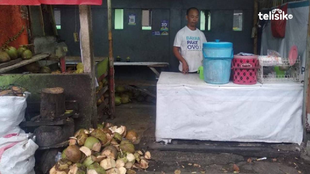 Masdi seorang penjual es kelapa muda yang mengeluhkan sepi pembeli saat musim hujan saat ini. Foto: Gede Suyana Sriski/Telisik.