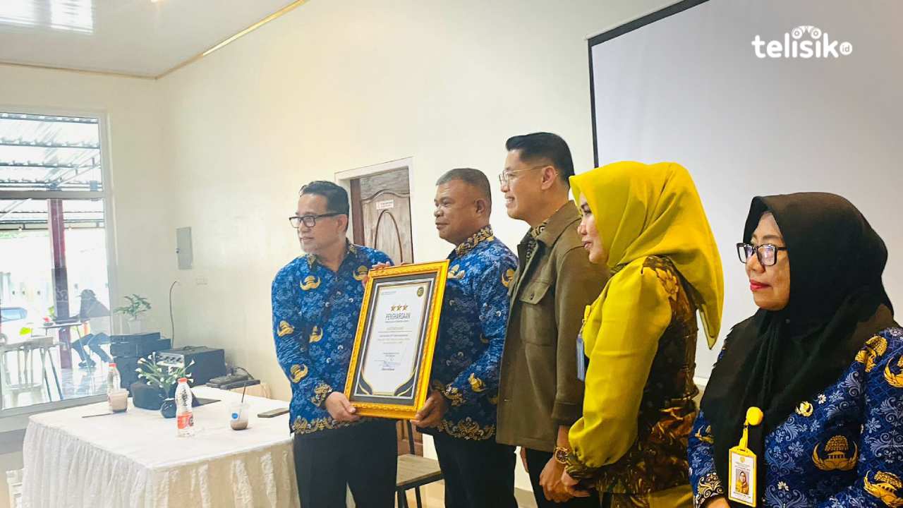 Kepala BPJS Kesehatan Baubau, Sarman Palipadang, bersama Plt Dinas Kesehatan Baubau, Frederik Tengke Allo, saat penyerahan piagam penghargaan, Rabu (18/2/2026). Foto: Elfinasari/Telisik