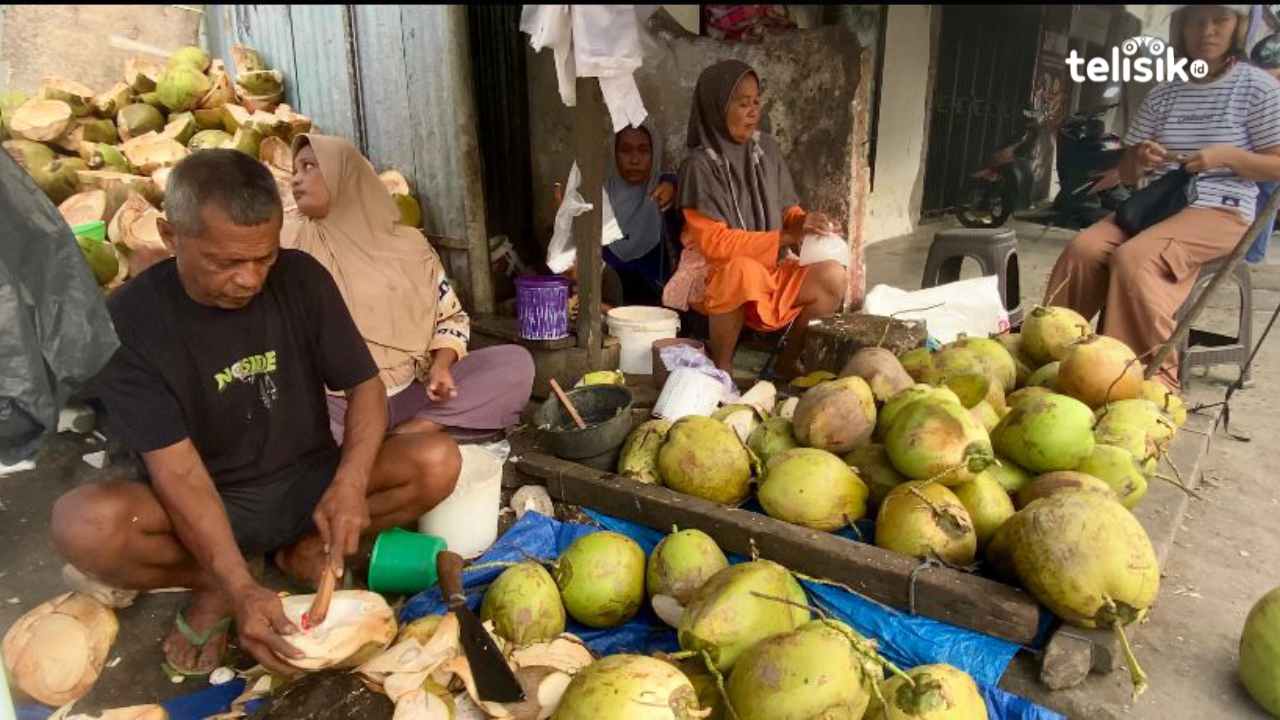 Penjual kelapa muda saat mengeruk kelapa untuk pembeli di sekitar Pasar Karya Nugraha, Kota Baubau, Rabu (4/3/2026). Foto: Elfinasari/Telisik