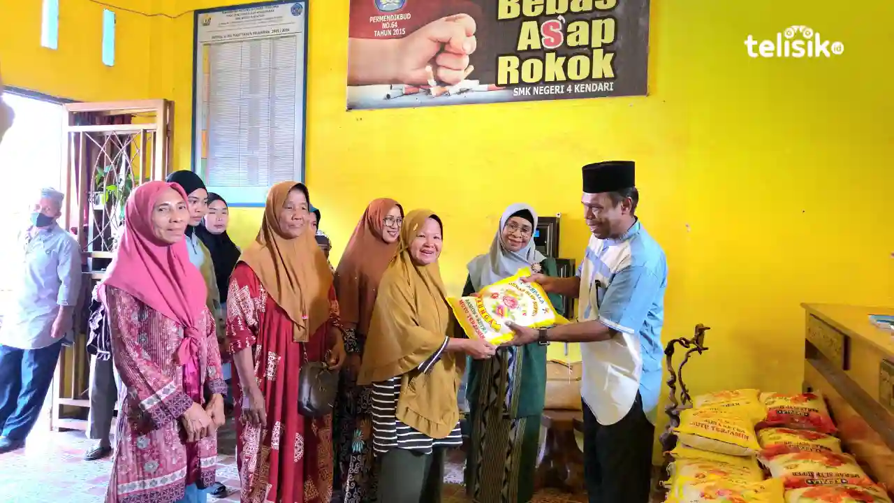 Kepala SMKN 4 Kendari, Herman (kanan), menyerahkan bantuan beras secara simbolis kepada salah satu penerima dalam program Berkah Ramadan di lingkungan SMKN 4 Kendari. Foto: Ana Pratiwi/Telisik