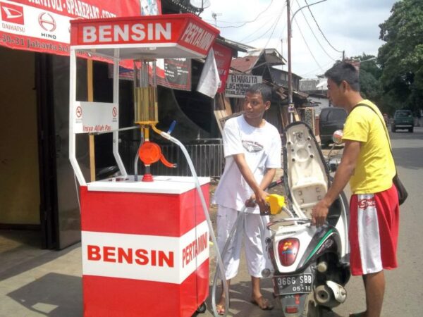 Warga mengisi bahan bakar di kios Pertamini yang disebut menjadi salah satu peluang usaha dengan modal terjangkau dan banyak diminati di desa. Foto: binabangunbangsa.com