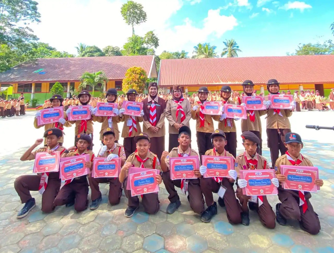 Sejumlah anggota Pramuka bersama pembina memegang piagam penghargaan usai mengikuti kegiatan di lingkungan sekolah, dalam rangka memperingati Hari Pramuka ke-65. Foto: Ist.