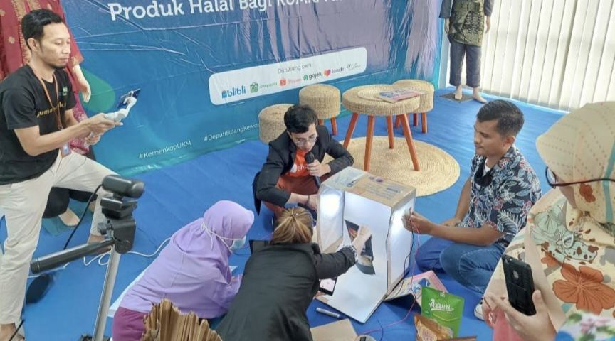 Pelaku UMKM mendapatkan pendampingan langsung dalam teknik pembuatan foto produk menggunakan light box saat mengikuti pelatihan digitalisasi pemasaran. Foto: ekon.go.id